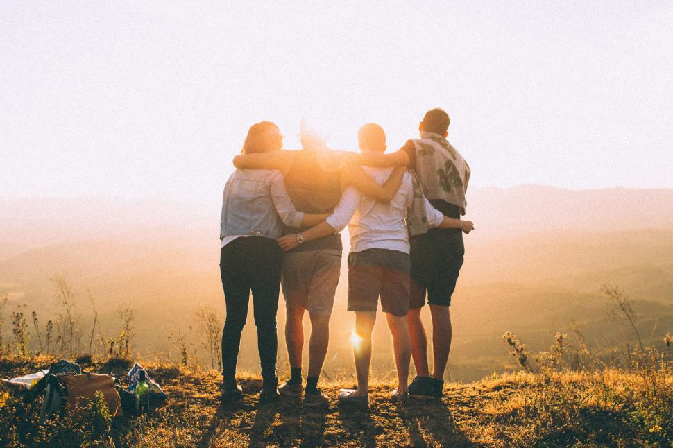 4 friends standing facinga sunset