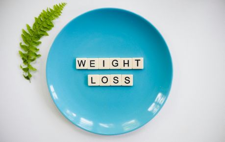 a picture of a blue plate with letter tiles on it that spell the words weight loss