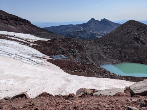 Picture of a glacier on top of South Sister mountain with a glacier lake and mountain range in the back ground